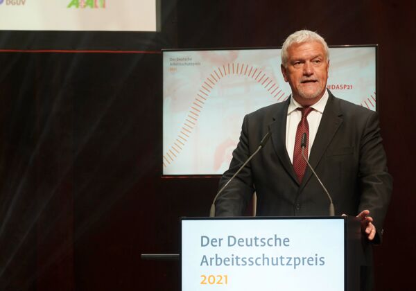 Manfred Wirsch steht hinter einem Rednerpult und hält Laudatio für die Kategorie "Kulturell"